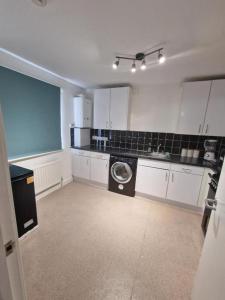 een keuken met een wasmachine in het midden bij Room in a shared Flat in Londen