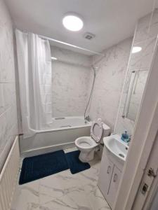 a white bathroom with a toilet and a sink at Room in a shared Flat in London