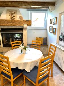 Un comedor con mesa y sillas y chimenea. en Olive Garden House, en Izola