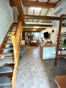 Habitación con escalera, sala de estar y cocina. en Olive Garden House, en Izola