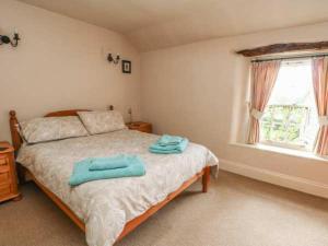 a bedroom with a bed with two towels on it at Beautiful 3-Bed House in Longnor near Buxton in Longnor