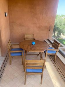 drewniany stół i krzesła w pokoju z oknem w obiekcie Appartement Privé 1 Chambre Vizir Center Marrakech w Marakeszu
