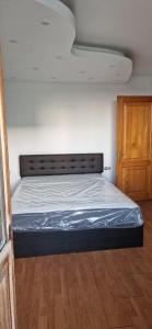 een bed in een kamer met een houten vloer bij ANASTASIA. in Tulcea