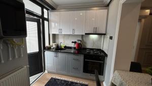 a kitchen with white cabinets and a stove top oven at KELES HOME in Trabzon