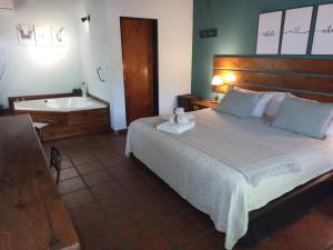 - une chambre avec un lit et une baignoire dans l'établissement Ruca Lemu, à Chascomús