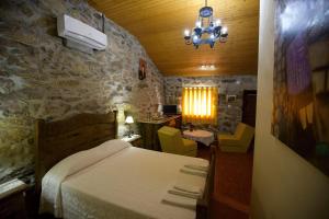 a bedroom with a bed and a stone wall at Aldeia do Codeçal in Codeçal
