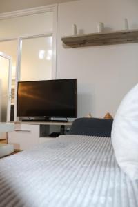 - une chambre avec un lit et une télévision à écran plat dans l'établissement Apartman Porodica Karalić Visoko, à Visoko