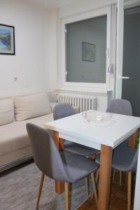 - un salon avec une table et des chaises blanches dans l'établissement Apartman Porodica Karalić Visoko, à Visoko