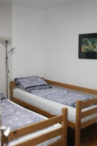 two beds sitting next to each other in a room at Apartman Porodica Karalić Visoko in Visoko