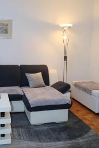 a room with a couch and a bed and a lamp at Apartman Porodica Karalić Visoko in Visoko