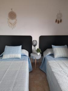 1 dormitorio con 2 camas y mesa con lámpara en Apartamento Serena beach, en Águilas