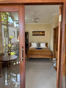 - une chambre avec un lit et une porte en verre dans l'établissement Yudis Guest House, à Ubud