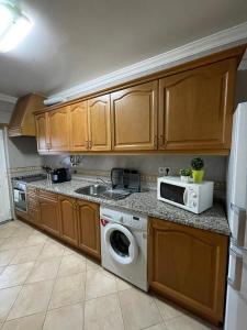una cucina con lavatrice e microonde di Apartamento Xelb a Silves