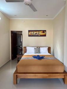 - une chambre dotée d'un grand lit avec un ruban bleu dans l'établissement Yudis Guest House, à Ubud