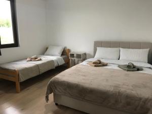 ムラデノバツにあるVilla Sladjanaのベッドルーム1室(ベッド2台、帽子付)