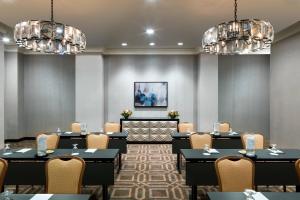 einen Konferenzraum mit Tischen, Stühlen und Kronleuchtern in der Unterkunft Sheraton Memphis Downtown Hotel in Memphis