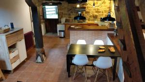 a kitchen with a black table and white chairs at Pidream Cottage . Cabañas de Pisueña in Selaya