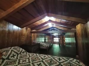 ein Schlafzimmer mit einem Bett und einem Sofa in einem Zimmer in der Unterkunft La Chonta in Mindo