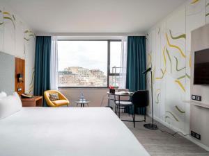 Habitación de hotel con cama grande y ventana en Mercure Antwerp City Centre, en Amberes