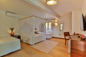 a bedroom with two beds and a canopy bed at Paraíso Ecológico Pousada & SPA in Arraial d'Ajuda