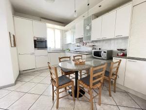 a kitchen with white cabinets and a table and chairs at Ca' del Monte in Roncofreddo +16 photos