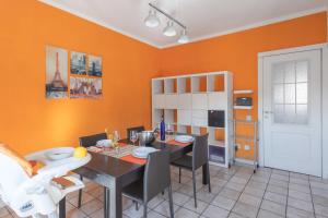 een eetkamer met oranje muren en een tafel en stoelen bij Casa Eleonora - Pavia - By HOST4U in Pavia