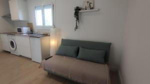 a living room with a couch and a kitchen at Casa con encanto in Corbera de Llobregat