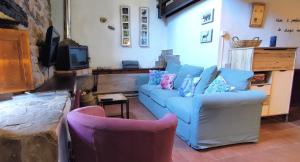 a living room with a blue couch and two chairs at Pidream Cottage . Cabañas de Pisueña in Selaya