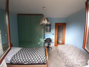 1 dormitorio con cama, escritorio y silla en Stanza nel verde a 14km da Torino, en La Loggia