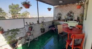 Una habitación con una mesa y algunas plantas en un balcón. en Departamento en Plaza de Yanahuara, en Arequipa