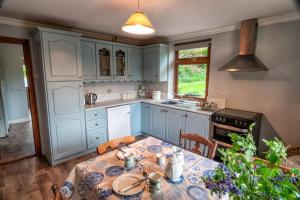 a kitchen with blue cabinets and a table and chairs at Maryfields Farmhouse in Castlemaine