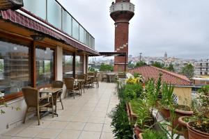 a patio with tables and chairs on a building at Altınboynuz Family Hotel in Istanbul