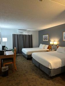 Habitación de hotel con 2 camas y escritorio en Wells Gray Inn, en Clearwater