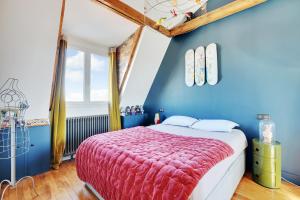 a bedroom with a bed and a blue wall at Villa Montmorency in Boulogne-Billancourt