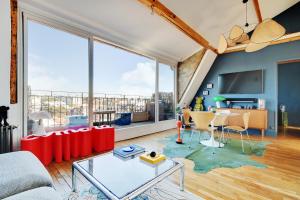 a living room with a large window and a table at Villa Montmorency in Boulogne-Billancourt