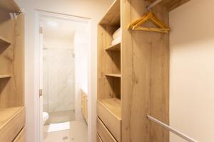 a bathroom with a closet with wooden shelves at Alcanfores by Wynwood House in Lima