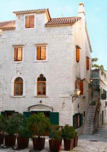um edifício com vasos de plantas à sua frente em Vanjaka bed and breakfast em Trogir