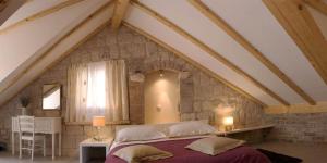 um quarto com uma cama grande num sótão em Vanjaka bed and breakfast em Trogir