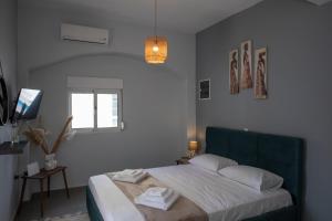 a bedroom with a bed with a blue headboard and a window at Suite of Liberty in Kos Town