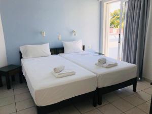 a bedroom with a large white bed with towels on it at Mediterranea Apartments in Kato Daratso