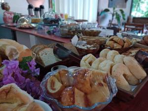 a table filled with different types of bread and pastries at Pousada Meraki in Serra do Cipo