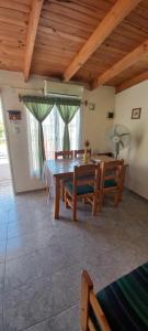 a dining room with a wooden table and benches at Cuty Nakey in Puerto Madryn