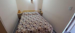 a small bedroom with a bed in a small room at Cuty Nakey in Puerto Madryn +4 photos
