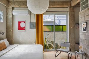 - une chambre avec un lit, une chaise et une fenêtre dans l'établissement DADA JAJA by DW, à San Juan