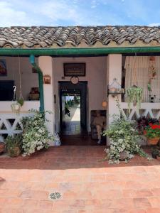 ein Haus mit einer Tür und einer Veranda mit Blumen in der Unterkunft Mi Ranchito, Centro in Barichara