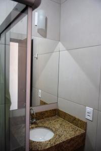 a bathroom with a sink and a mirror at Residencial Lucernaré - Resende in Itacaré