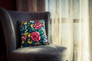 a pillow sitting on a chair next to a window at Delorenzo Studio Apartments in Nelson