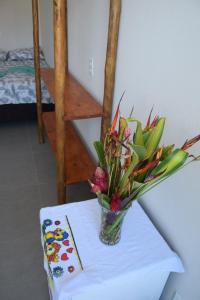 a vase of flowers sitting on a table at Residencial Lucernaré - Resende in Itacaré