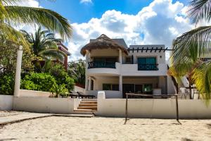 a white house on the beach with palm trees at Salamina Luxury private house in Uaymitun