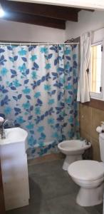 uma casa de banho com 2 WC e uma cortina de chuveiro com peixes em Doña Vicenta em Pilar